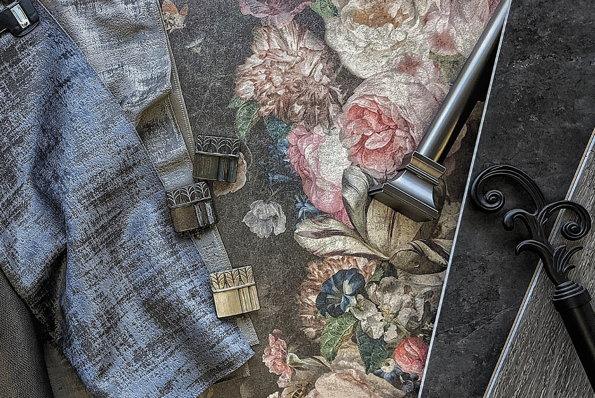 Drapery fabrics and a decorative curtain rod finial on a floral textile